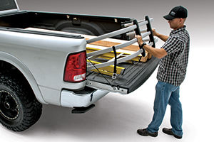 Mostly greyed-out picture of a man pulling tools out of the bed of his truck