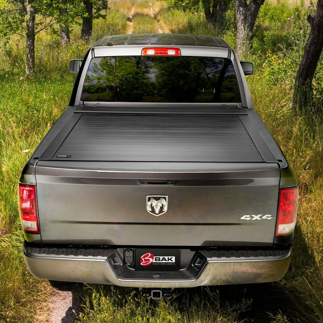 Picture of a grey 4x4 Dodge truck with a tonneau cover parked in the woods