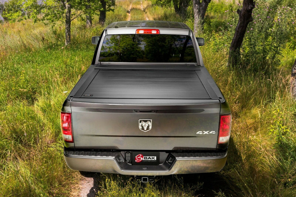 Picture of a grey 4x4 Dodge truck with a tonneau cover parked in the woods