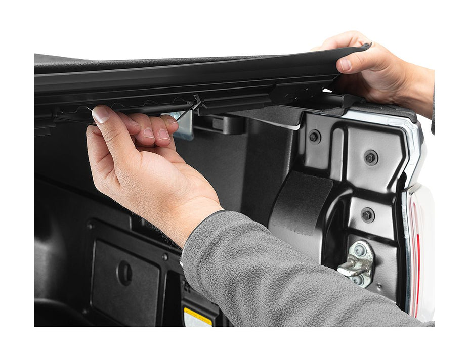 Image of a hand pulling security latch on tonneau cover. 