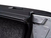 Open car door handle next to a Bakflip MX4 hard folding tonneau cover, showcasing vehicle access.