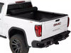 Rear of a white truck with a black bed, showcasing the BAK Revolver X4S Tonneau Cover on top