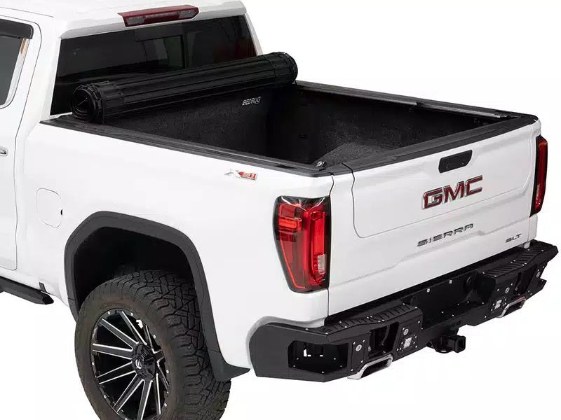 Rear of a white truck with a black bed, showcasing the BAK Revolver X4S Tonneau Cover on top