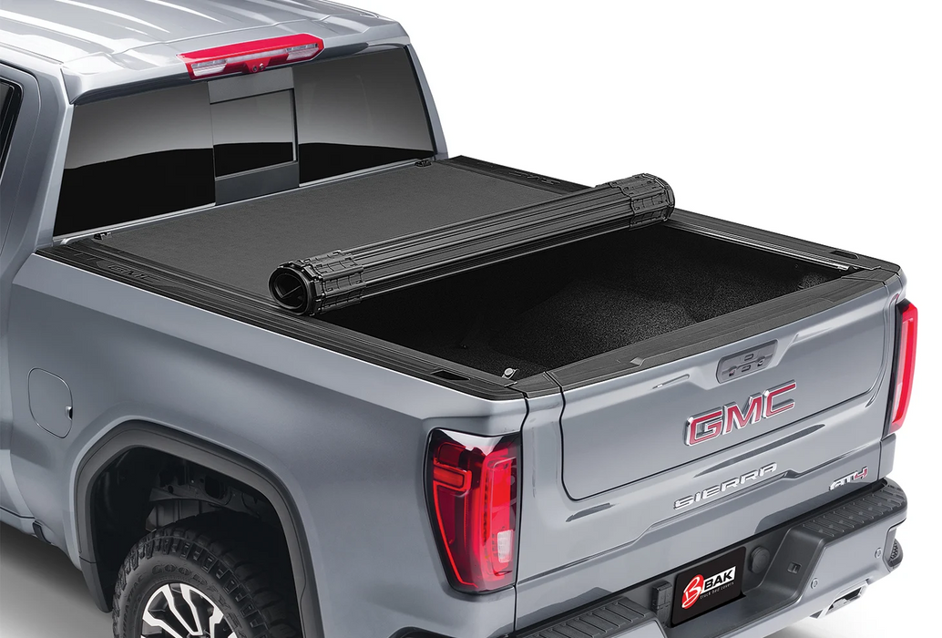 Silver truck bed featuring a BAK Revolver X4S tonneau cover in black.