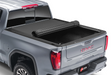 Silver truck bed featuring a BAK Revolver X4S tonneau cover in black.